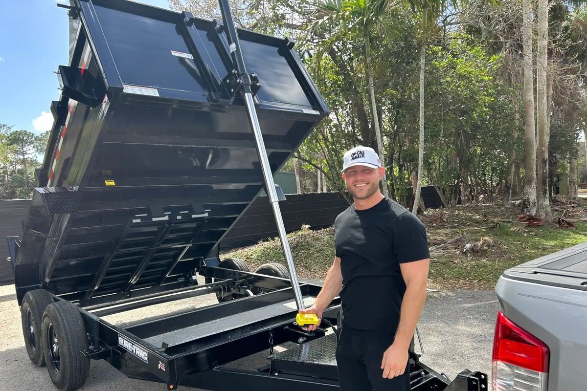 Tyler of On-Call Hauler with the dump trailer raised, ready to place a load of landscape material in Royal Palm Beach, Florida
